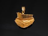 a close up of a gold pendant with a boat on it