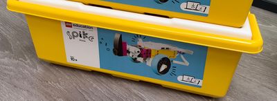 two yellow boxes with legos on them sitting on the floor