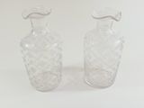 two clear glass vases sitting next to each other on a white surface