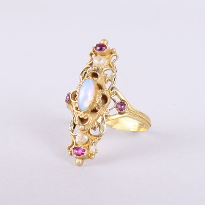 une image représentant une bague en or sertie d'un oplite blanc et de saphirs roses