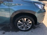 a close up of a blue car parked in a parking lot