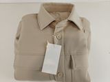 the shirt is tan and has a tag on the collar