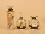 three bottles of perfume sitting next to each other on a table