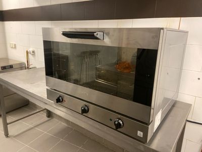 un four argenté posé sur un plan de travail dans une cuisine