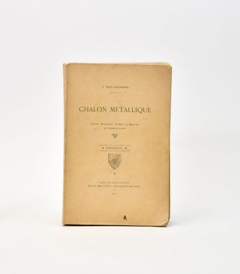 un vieux livre posé sur une table, à côté d'un verre