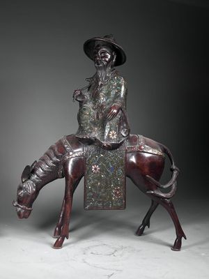bronze statue of a man riding a horse with a hat on his head