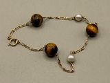 bracelet composé de perles « œil-de-tigre » et de perles de culture, montées sur une chaîne plaquée or