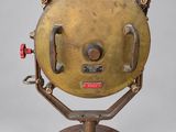 an old brass plate with a red handle on a stand
