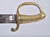 a close up of a gold colored sword with a black handle