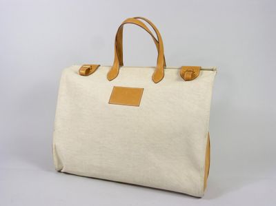 un sac en toile blanche avec des anses en cuir beige sur fond blanc