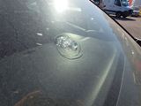 a car that has a bullet hole in the windshield of it