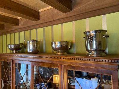de nombreux bols en argent posés sur une armoire en bois