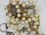 a pile of pearls and other jewelry on a table