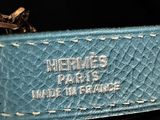 the blue leather belt has a gold buckle on it