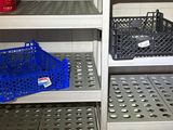 a metal shelf with baskets on it in a kitchen