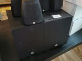 four speakers sitting on a black table in a living room