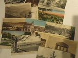 de nombreuses cartes postales anciennes posées sur une table, à côté d'une tasse de café