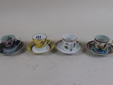 four cups and saucers are lined up on a white surface