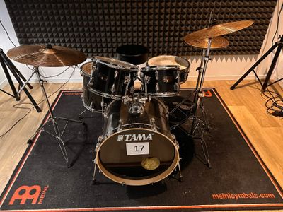 a drum set that is sitting on a mat in front of a microphone