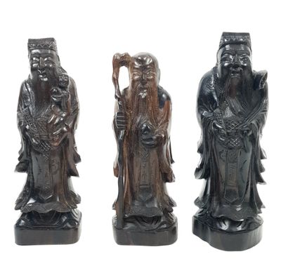 three carved figurines of men with hats and beards