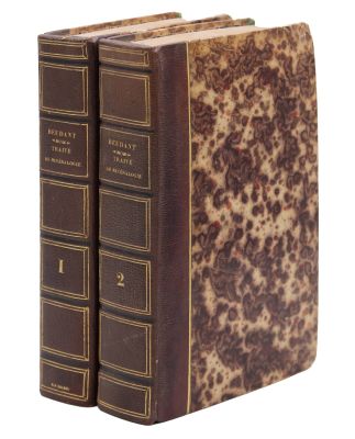 deux livres sont posés l'un sur l'autre sur une surface blanche