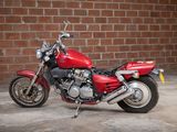 a red motorcycle parked in front of a brick wall
