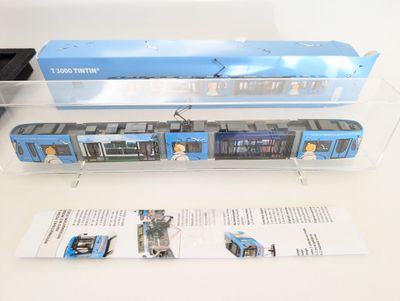a blue and white train on display in a clear box