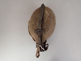 an old helmet hanging on a wall with a chain