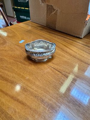 a silver plate on a wooden table with a box in the background