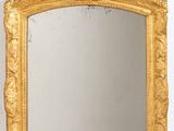 une image d'un miroir encadré d'or sur un mur blanc