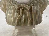 marble bust of a woman with a bow around her neck