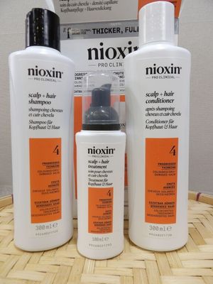 three bottles of nioxin hair care sitting on a table
