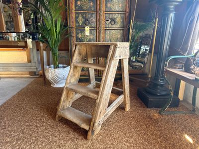 a wooden step stool in the middle of a living room