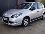 a picture of a small silver car parked in front of a building