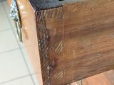 a close up of a wooden drawer with a black lid