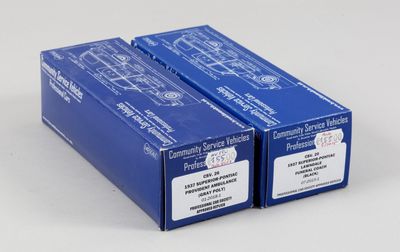 deux boîtes bleues portant des étiquettes, posées sur une surface blanche
