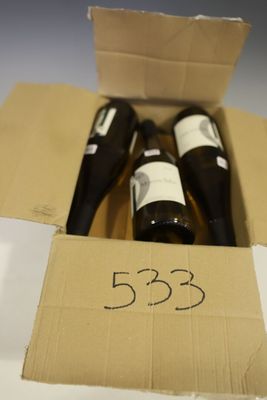 three bottles of wine in a cardboard box on a table