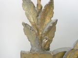 a metal sculpture of a plant with leaves on top of it