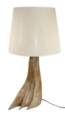 table lamp in the shape of a bird ' s foot with a white shade