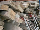 a pile of wood sitting on the ground next to a pile of other wood