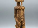 an old wooden statue of a man with a helmet on his head