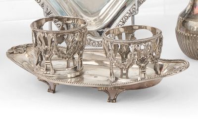 un plateau en argent sur lequel sont posées des tasses et des soucoupes