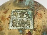 a close up of a metal object with a chinese writing on it