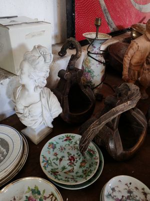 une table sur laquelle se trouvent de nombreuses assiettes et une statue