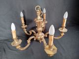 a gold chandelier with five lights on a black background