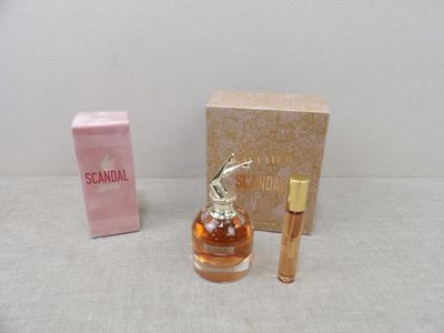 un petit flacon de parfum à côté d'une petite boîte