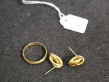 deux bagues en or et une paire de boucles d'oreilles posées sur une table