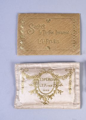 two gold business cards and a gold purse on a blue surface