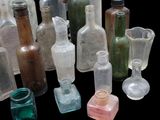 many different colored glass bottles sitting on a black surface