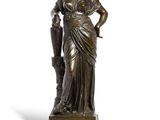 une statue antique en bronze représentant une femme tenant un parapluie